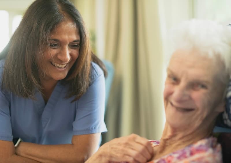 A nurse caring for an elderly patient at home