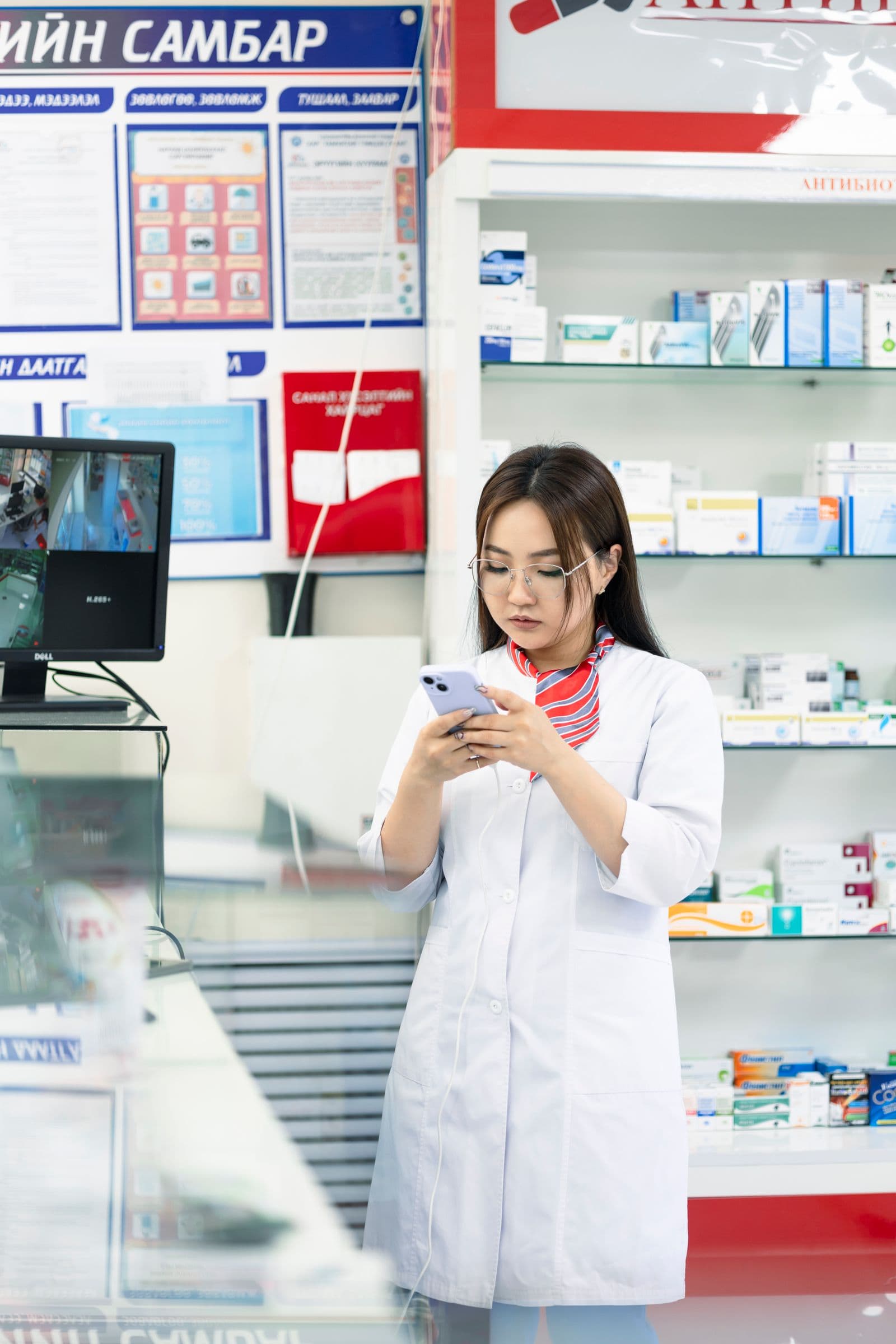 Pharmacist checking medicine availability at the shelves